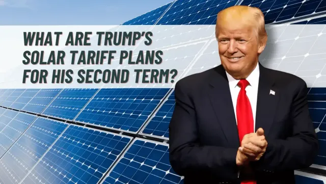 A man in a suit and tie is standing in front of solar panels.