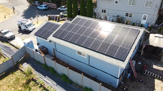 An aerial view of a house with solar panels on the roof.