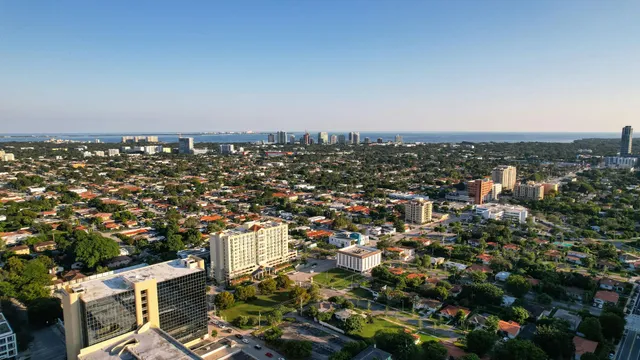 Aerial view of a sprawling cityscape with dense neighborhoods and buildings under a clear sky.