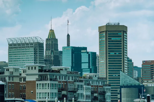 City skyline with modern high-rise buildings under a cloudy blue sky