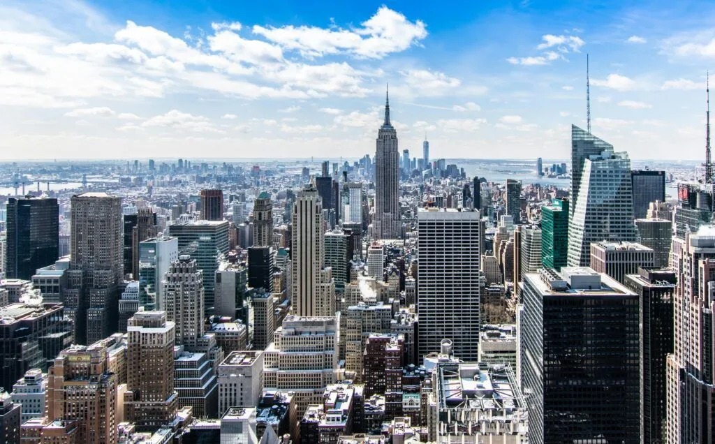 Panoramic view of New York City skyline with the Empire State Building under a bright blue sky